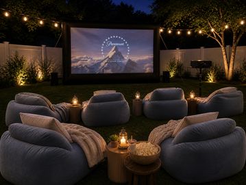 Cozy outdoor movie night setup with bean bags and string lights.