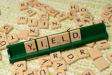 Letter Tiles spelling out YIELD - in reference to passive income opportunities that pay dividends