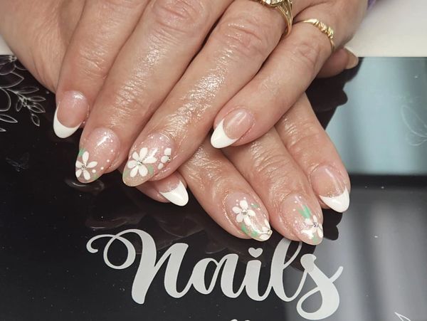 French manicure with floral nail art on natural nails.
