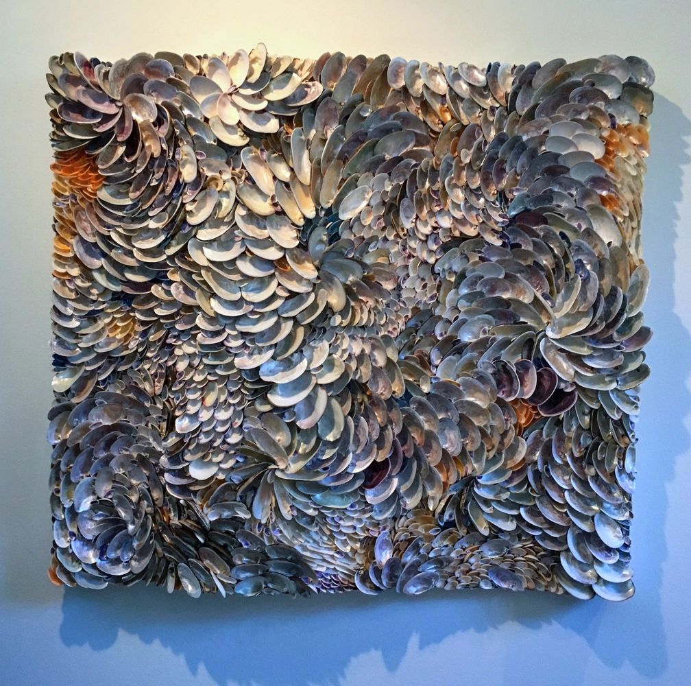 "Catching the Last Wave" is a wall sculpture  made of mussel shells with undulating depths.