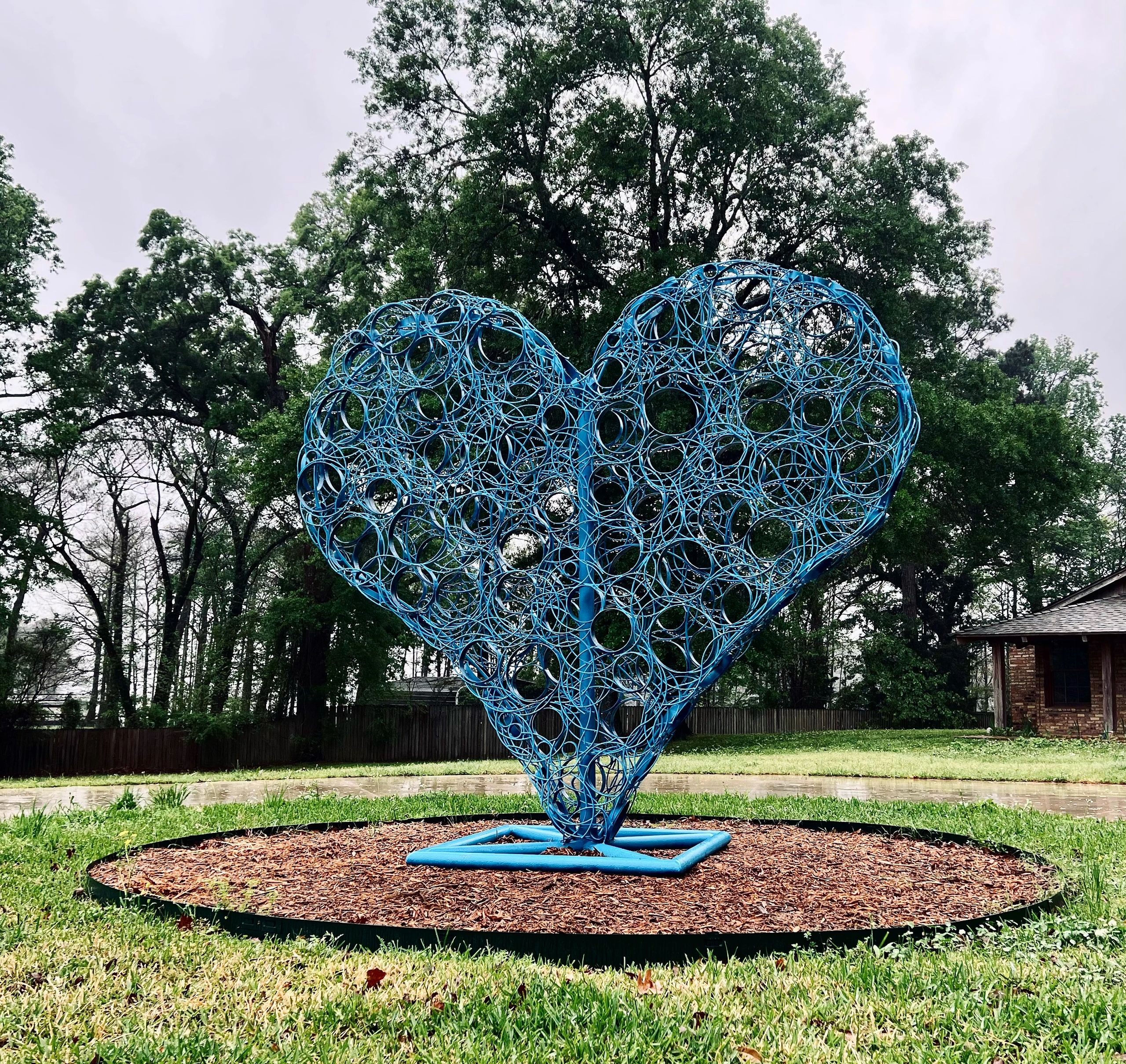 "Open Heart" is a painted steel heart shaped sculpture.