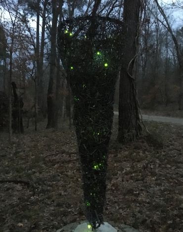 Nighttime outdoor view of floor sculpture "Calculated Chaos."