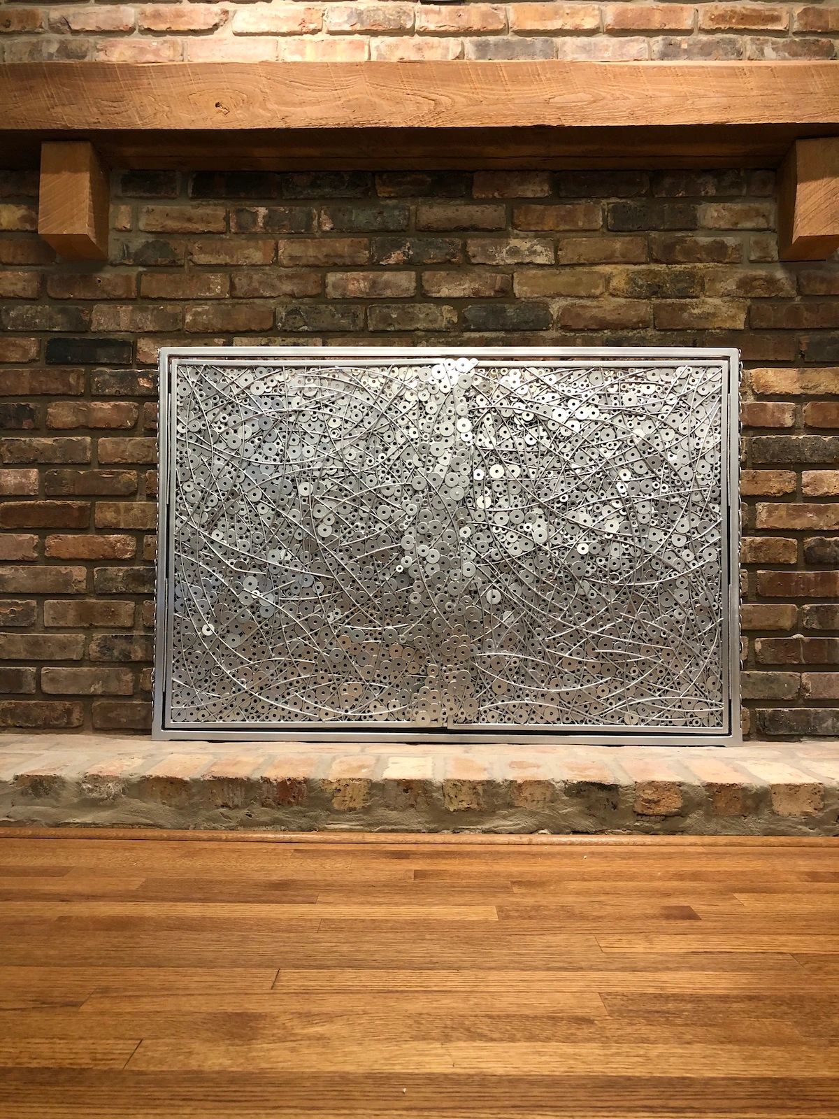 Silver colored fireplace screen created by Tamara Robertson. 