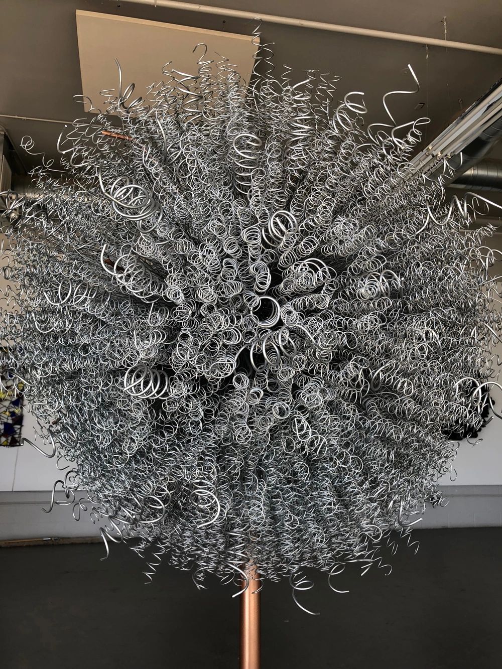 "Brio" sculpture made of hundreds of hand coiled steel wires radiating from a central point.