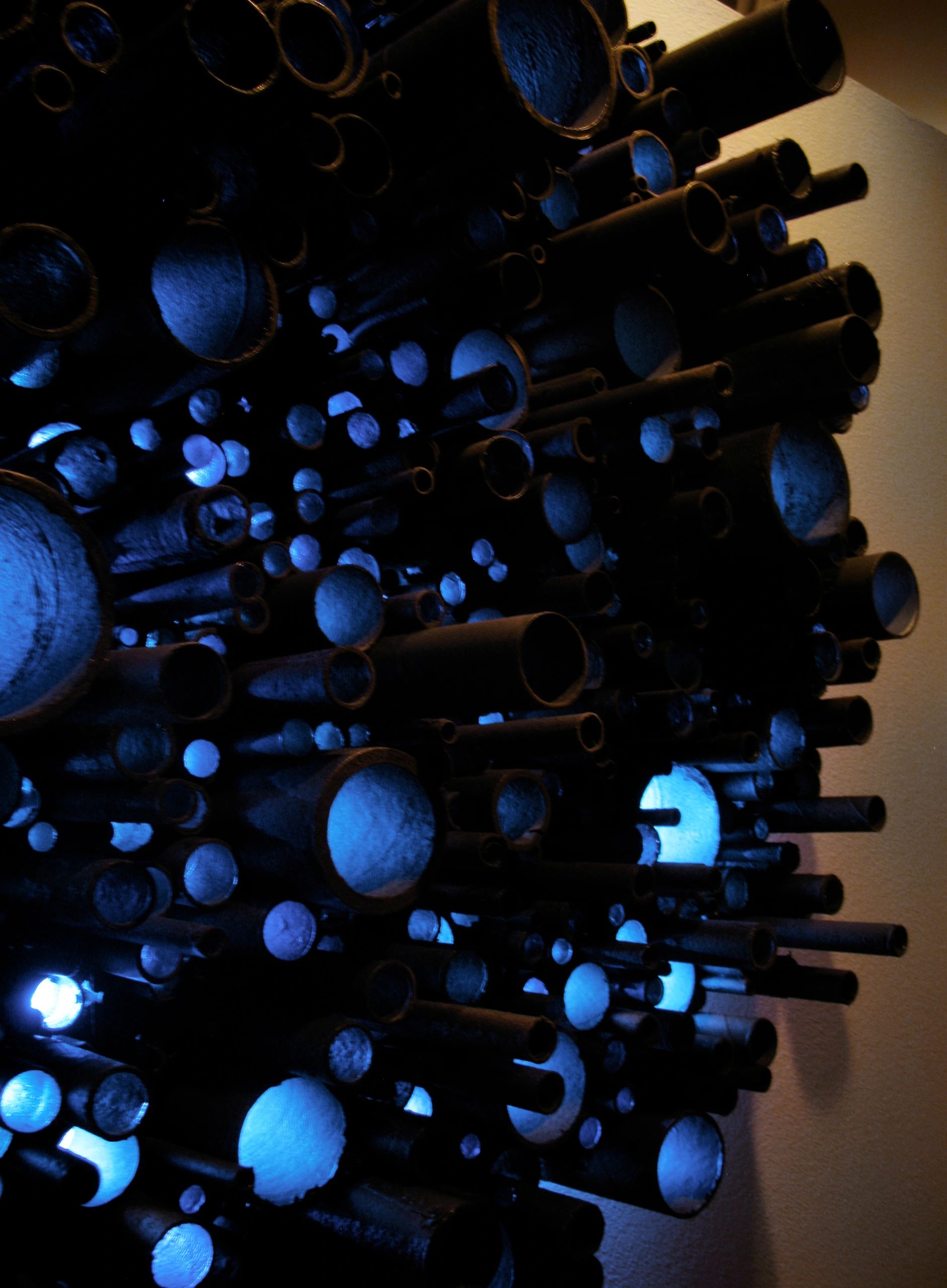"Galaxy" is a wall sculpture made of firecracker tubes and light.