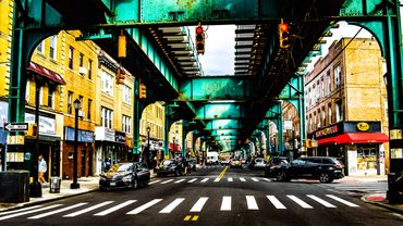 Photography of a narrow street under the rail in New York. Colorful and vibrant.