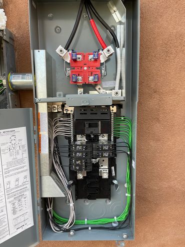 Open electrical panel with wires and circuit breakers.
