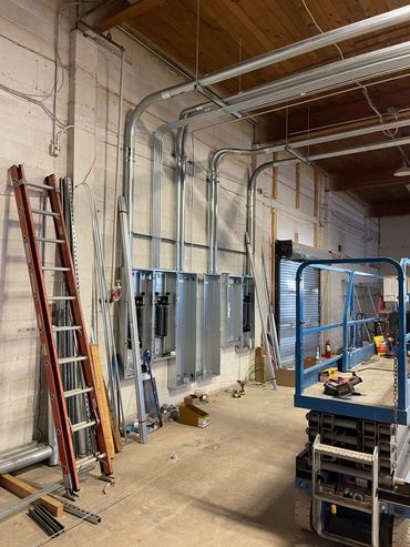 Electrical wiring installation in progress in a warehouse.