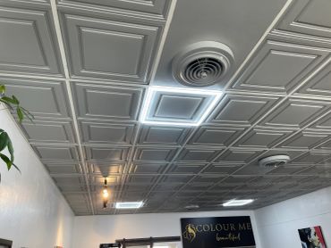 Modern ceiling with lights and air vents.