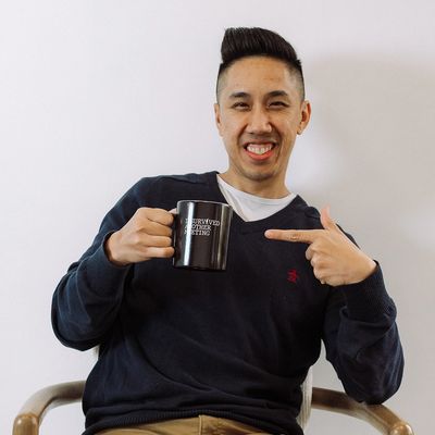 Man smiling and pointing at a black mug.