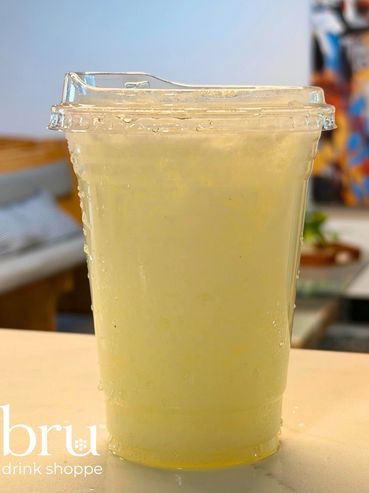 Chilled lemonade in a plastic cup with condensation drops.