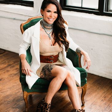 Woman sitting on a green armchair smiling.