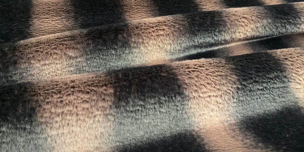 Close-up of soft, patterned fabric with shadows creating depth.