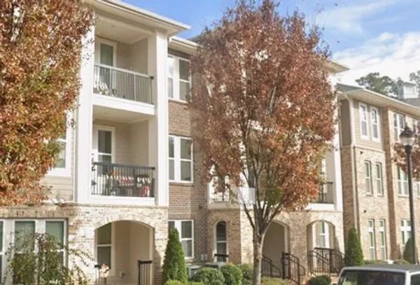 Modern apartment complex with autumn trees in front.