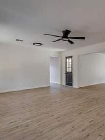 Living and dining area with white walls, wood-look flooring, recessed lighting, and a black ceiling