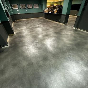 Empty room with polished concrete floor and teal walls.