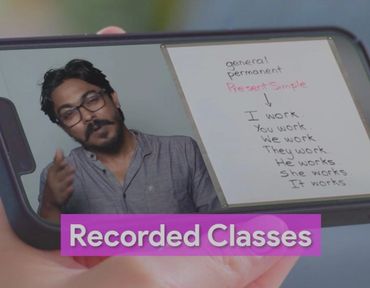 Man teaching Present Simple tense in a recorded class on a smartphone.