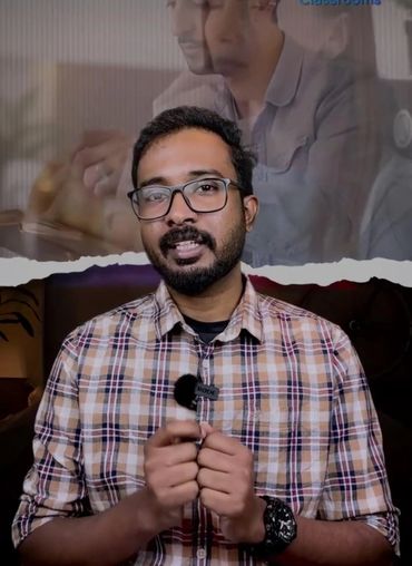 Man in plaid shirt speaking with a microphone clipped to his collar.