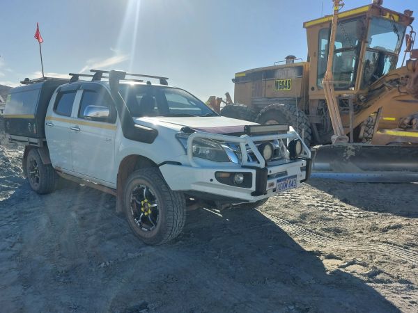 White off-road pickup truck parked on dirt.
