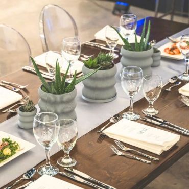 Elegant table setting with white plants and glassware.
