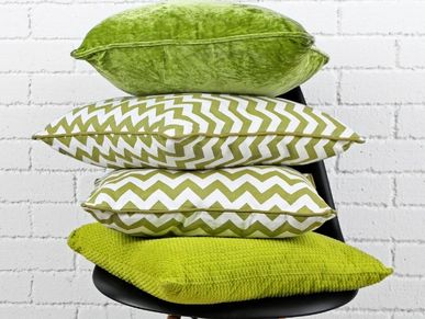 Stack of green and white patterned pillows on a black chair.
