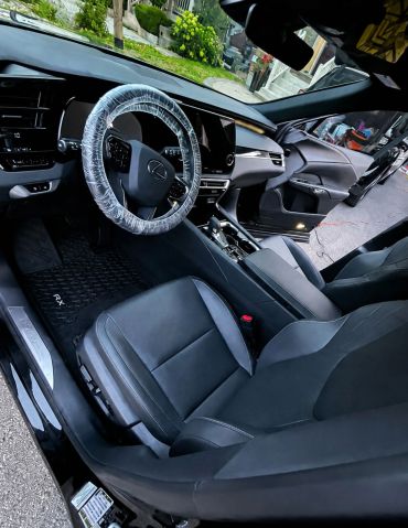 Interior of a Lexus RX with plastic-covered steering wheel.