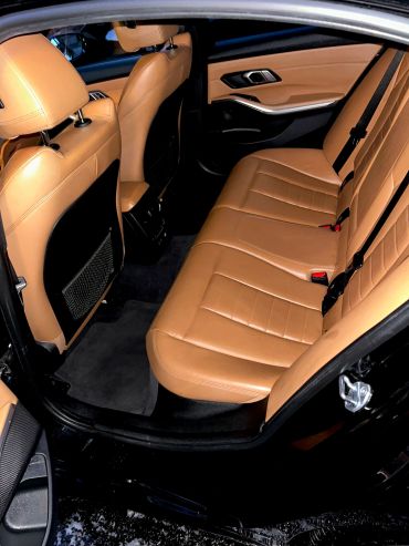 Clean tan leather interior of a car's back seat.