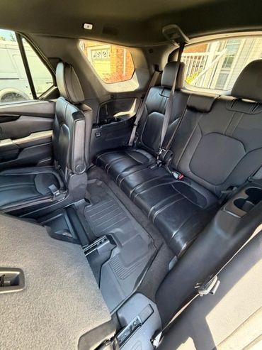 Interior of a car with black leather seats and a window view.