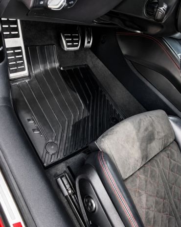 Car interior showing floor mats and pedals.