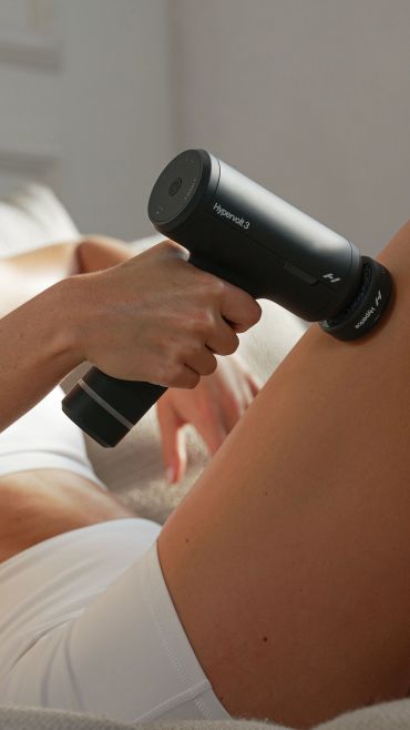 Massage gun on leg.