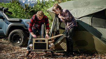 A couple camping with a tent and a heater.