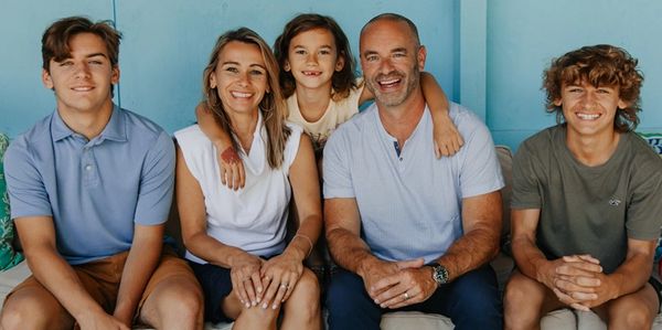 Happy family of five sitting together and smiling.
