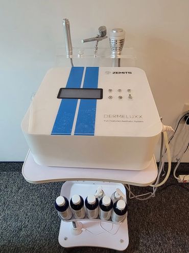 Close up of the DermeLuxx Hydro dermabrasion machine with attachments and serums
