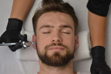 Man having his facial skin using the Oxygen Infusion wand on the Hydrodermabrasion/DermeLuxx machine