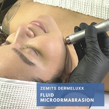 woman enjoying the fluid Hydrodermabrasion wand to gentle remove skin cells.  DermeLuxx