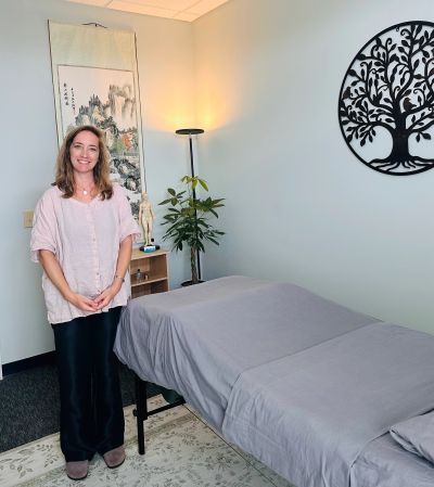Woman standing in a therapy or massage room.