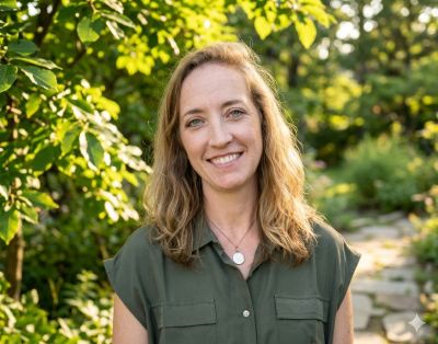 Smiling woman outdoors with natural background.