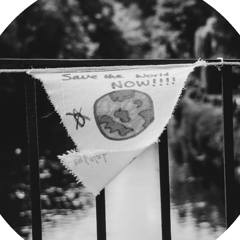 Logo, ein dreieckiges Transparent mit der Aufschrift SAVE THE WORLD NOW