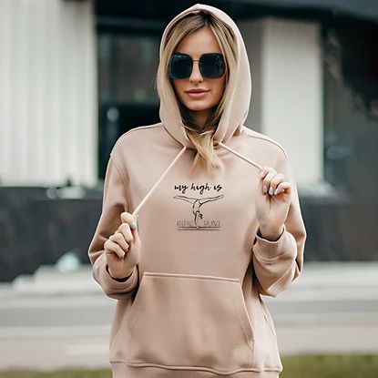 a woman in a cream color hoodie and glasses