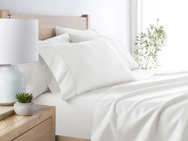 White bed sheets and pillows in a bedroom.