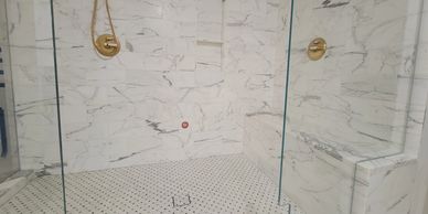 Calacatta marble steam shower with a sitting bench and a recessed niche