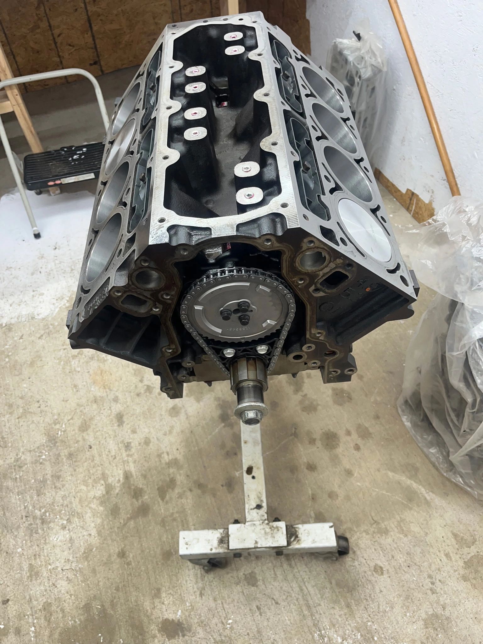 A V8 engine block mounted on a stand in a workshop.