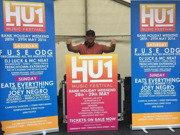 A man poses behind HU1 Music Festival banners promoting the May 2016 event.