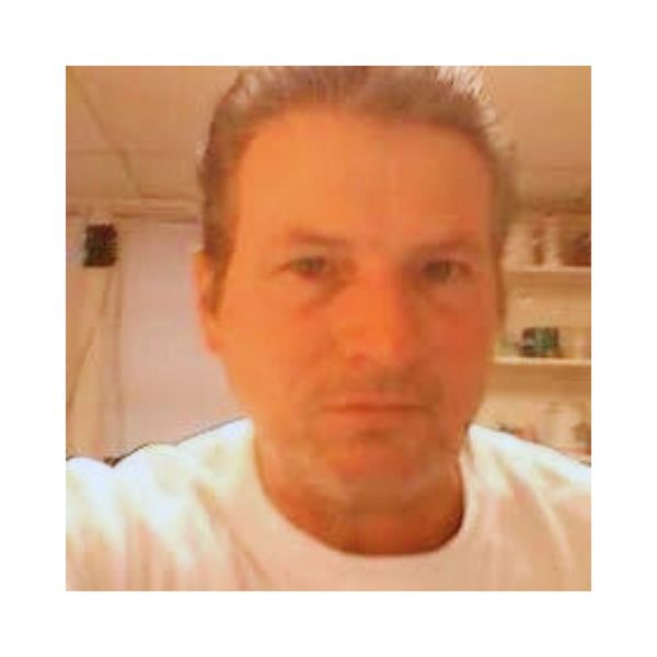 Blurry close-up of a man in a white shirt indoors.