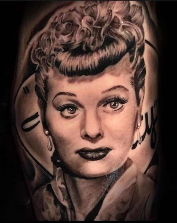 Realistic black and gray tattoo portrait of a vintage woman with styled hair and earrings.