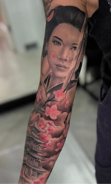 Sleeve tattoo featuring a geisha with cherry blossoms and a traditional Japanese pagoda.
