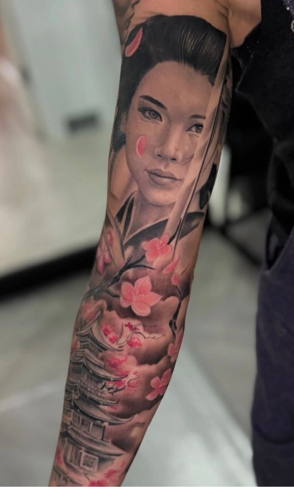 Sleeve tattoo featuring a geisha with cherry blossoms and a traditional Japanese pagoda.