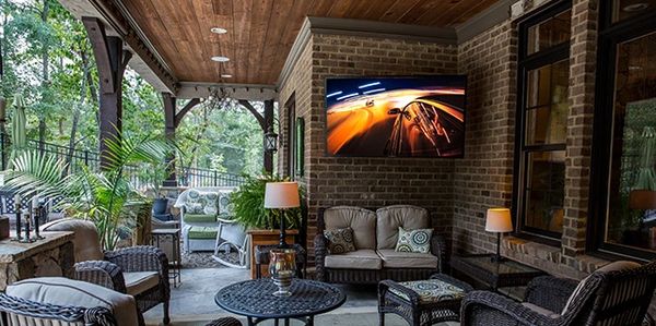 Outdoor TV setup in Toronto backyard with lounge seating and entertainment system.