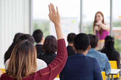 Woman with hand raised in training class