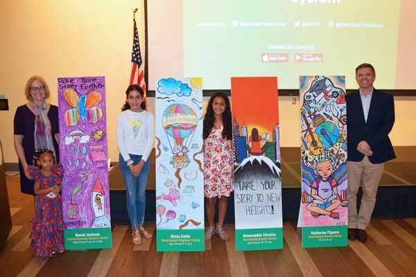 Winners of the bookmark competition posing with their winning bookmark designs.